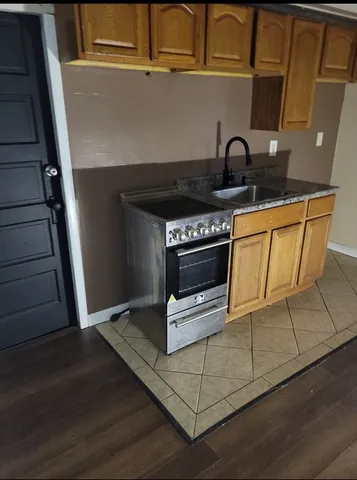 a kitchen with granite countertop a stove a sink and a microwave