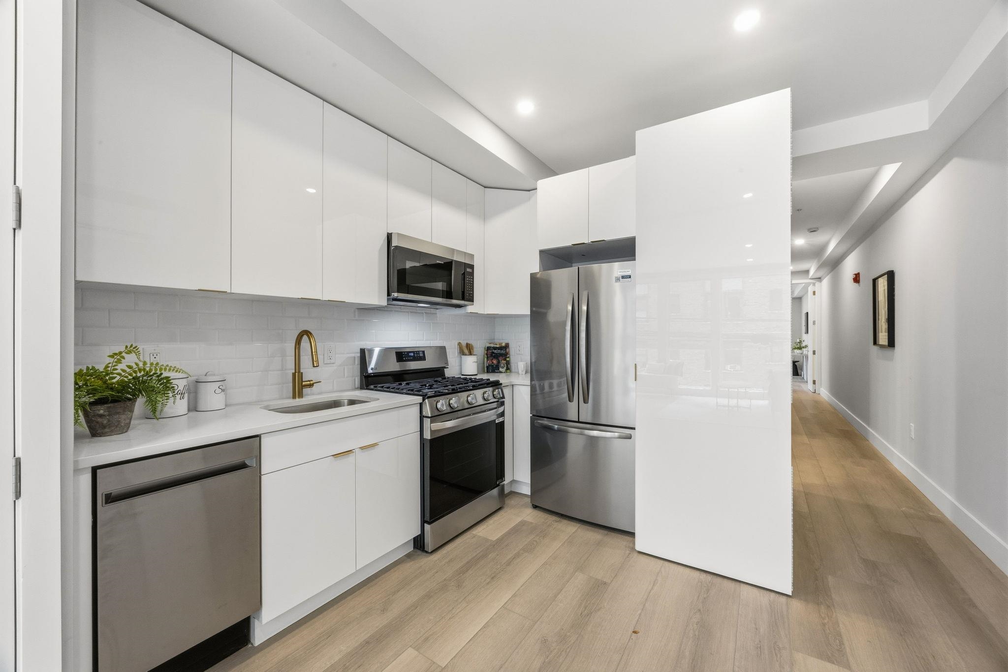 77 Van Reypen Street, Unit 3 Jersey City, NJ 07306 - Photo 1 of 23 a kitchen with stainless steel appliances a refrigerator stove microwave and sink
