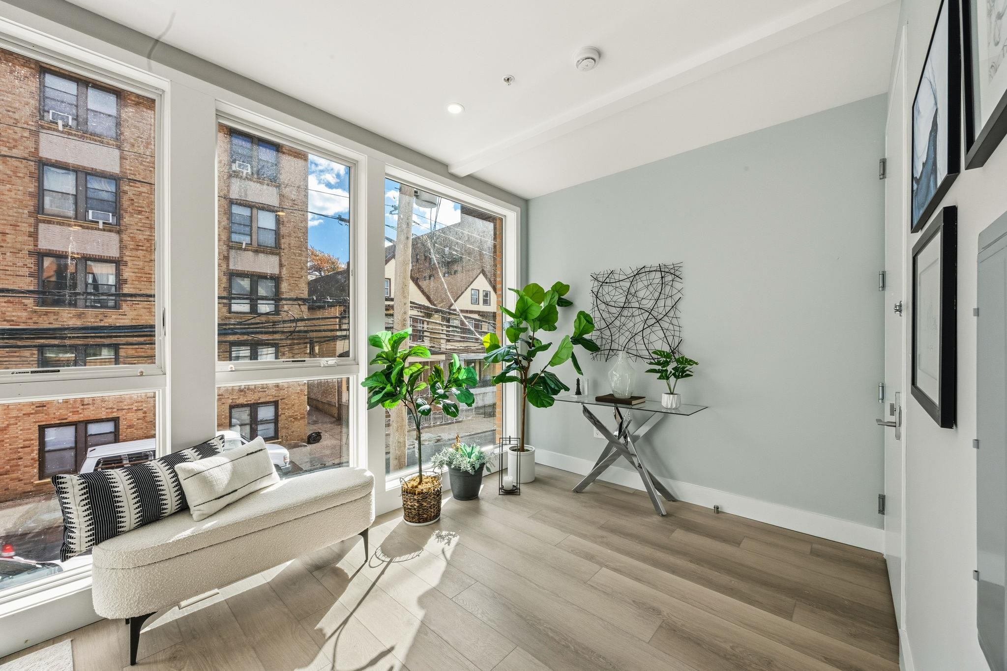 77 Van Reypen Street, Unit 3 Jersey City, NJ 07306 - Photo 21 of 23 a living room with furniture windows and a potted plant