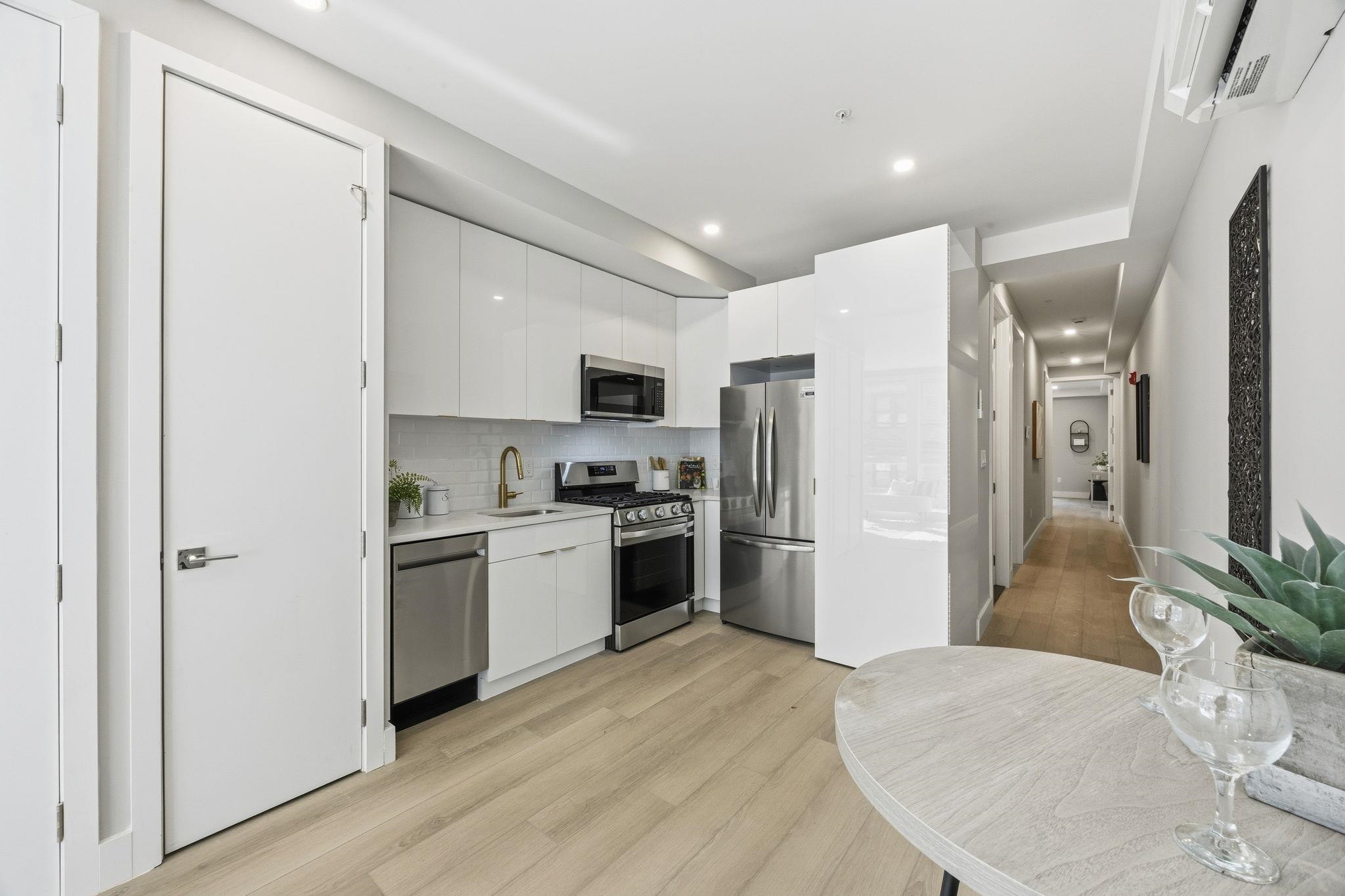77 Van Reypen Street, Unit 3 Jersey City, NJ 07306 - Photo 22 of 23 a kitchen with refrigerator a sink and white cabinets
