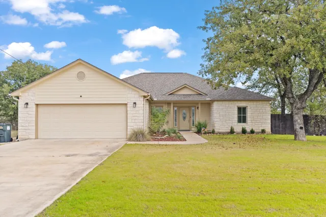 a front view of a house with a yard and garage