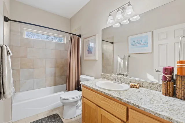 a bathroom with a granite countertop sink toilet a mirror and shower