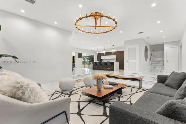 a room with stainless steel appliances kitchen island granite countertop a sink and cabinets