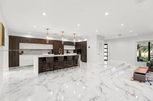 a kitchen with kitchen island a sink stainless steel appliances and counter space