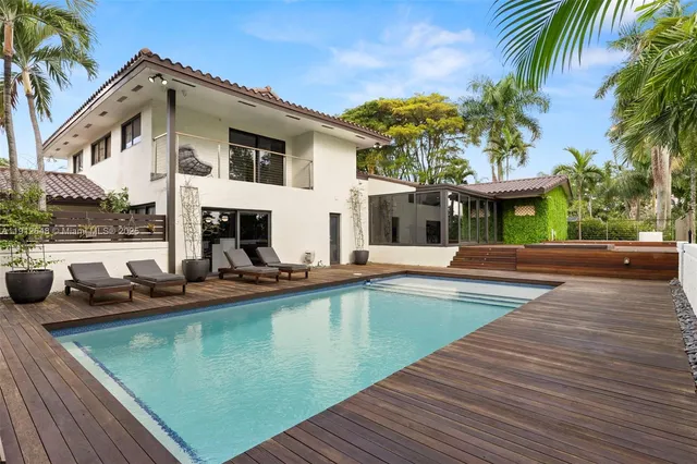 a large living room with stainless steel appliances kitchen island granite countertop a large window in it