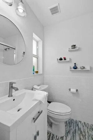 a bathroom with a sink mirror and toilet