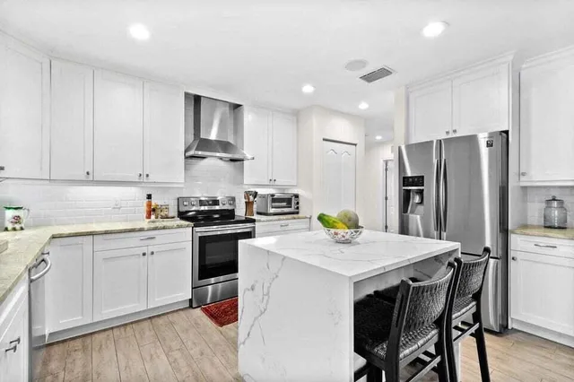 a kitchen with a stove a refrigerator and a dining table