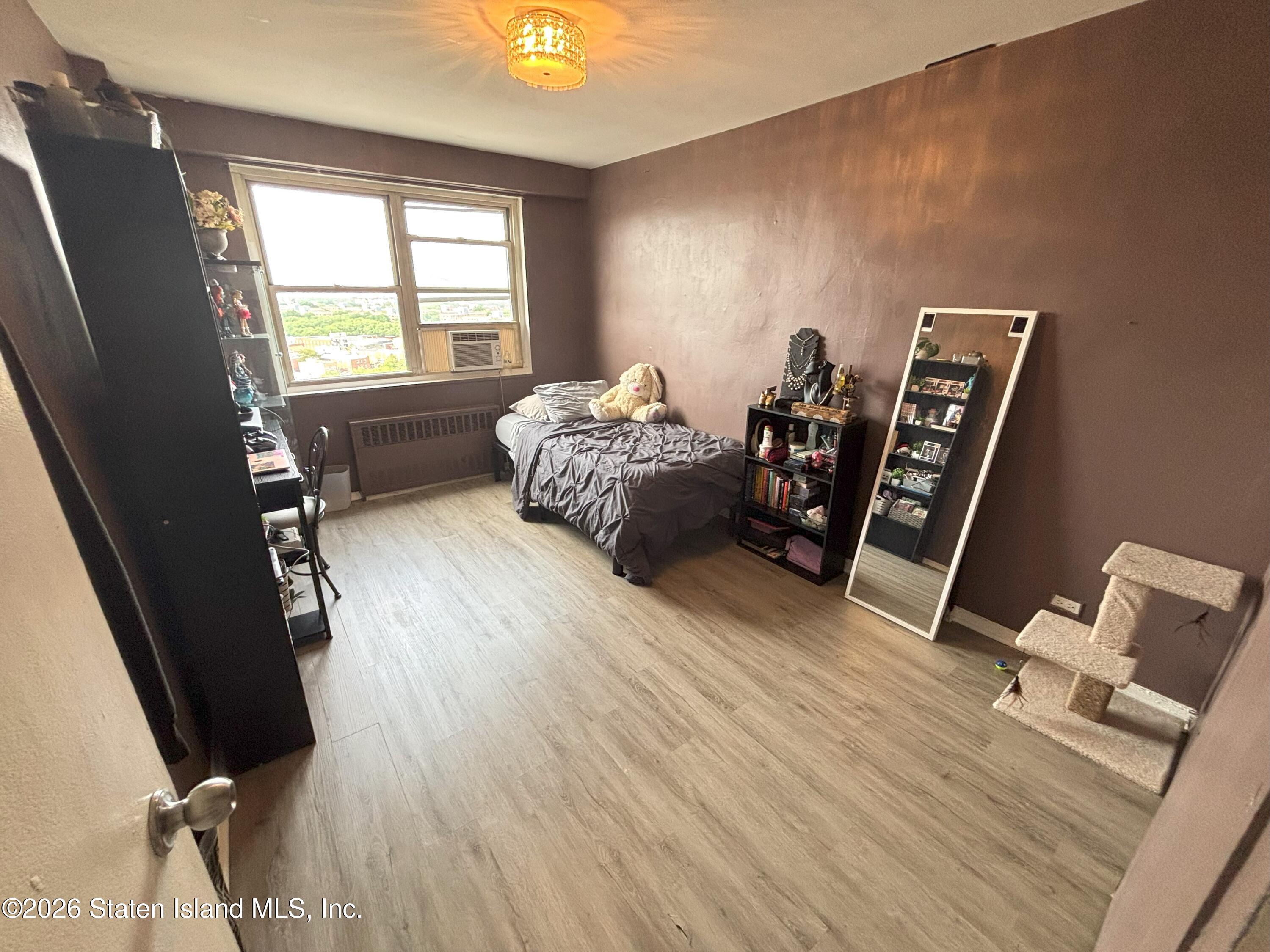 2483 West 16th Street, Unit 15F Brooklyn, NY 11214 - Photo 19 of 25 a bed sitting in a bedroom next to a window