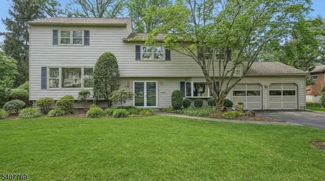 a front view of a house with a yard and potted plants