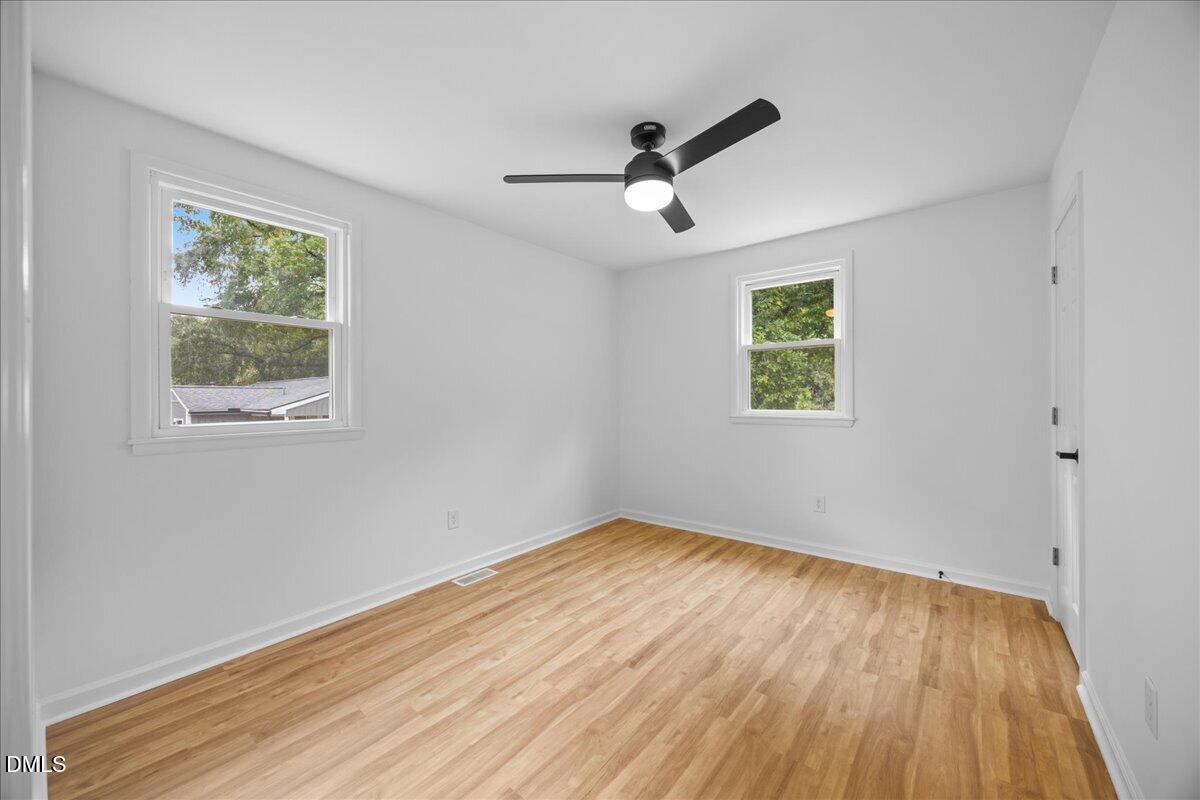 3437 Apache Drive Raleigh, NC 27609 - Photo 21 of 40 LVP flooring, white walls, and a black ceiling fan with integrated lighting