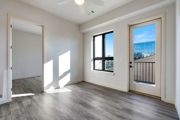 an empty room with wooden floor and windows
