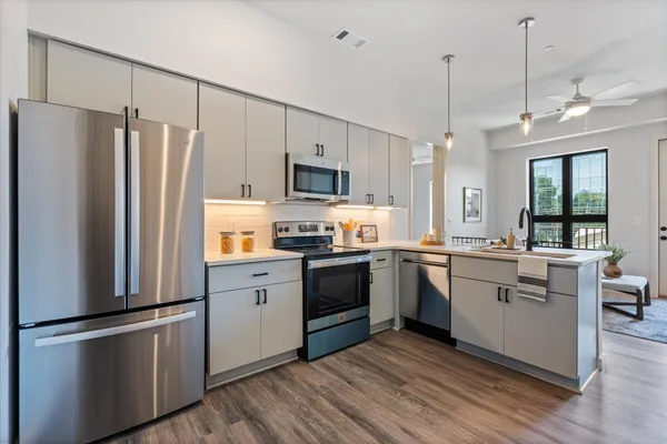a kitchen with stainless steel appliances a refrigerator sink and microwave