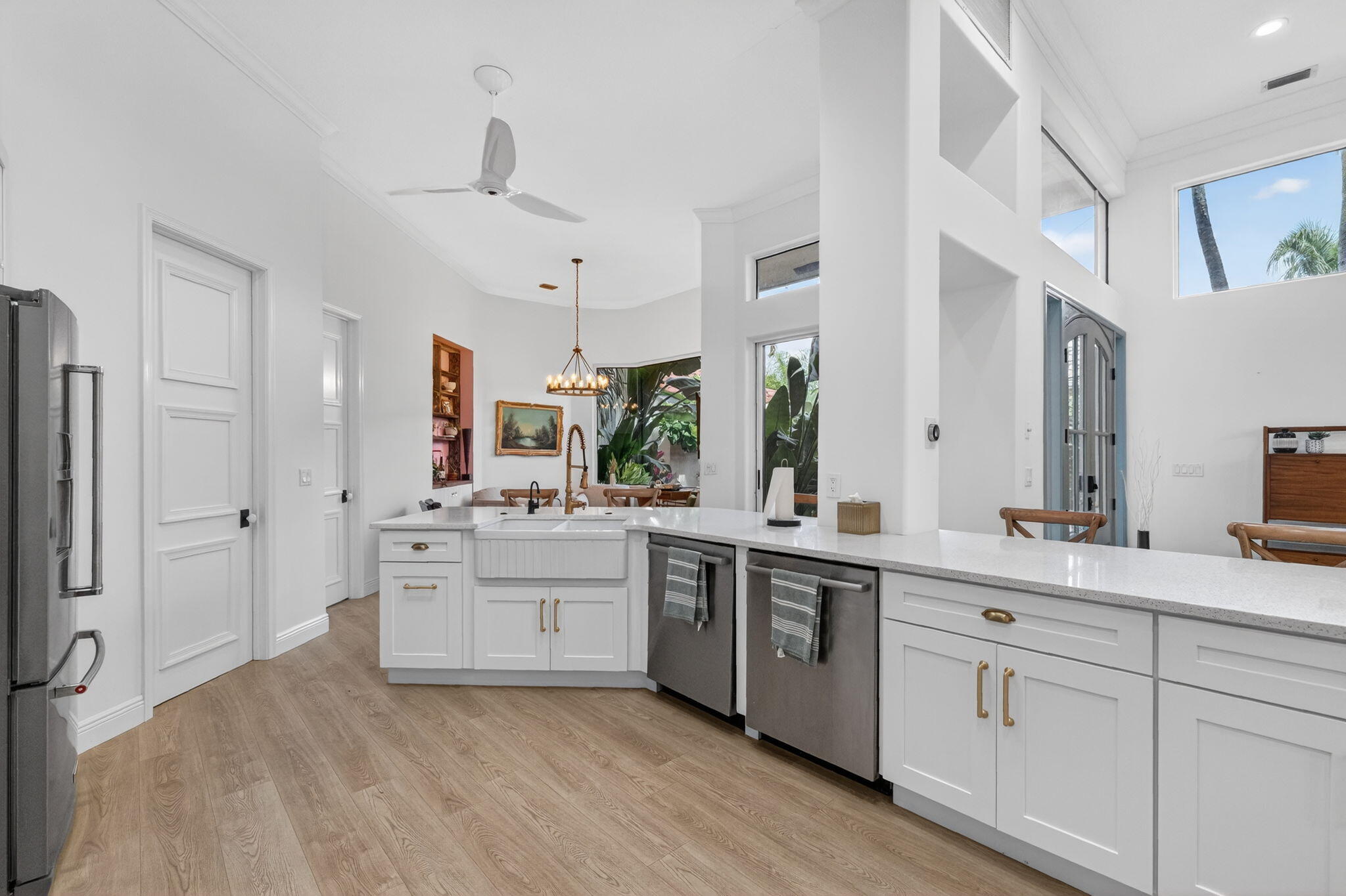 7450 Campo Florido Boca Raton, FL 33433 - Photo 17 of 63 a large white kitchen with a stove a sink dishwasher a refrigerator and white cabinets with wooden floor