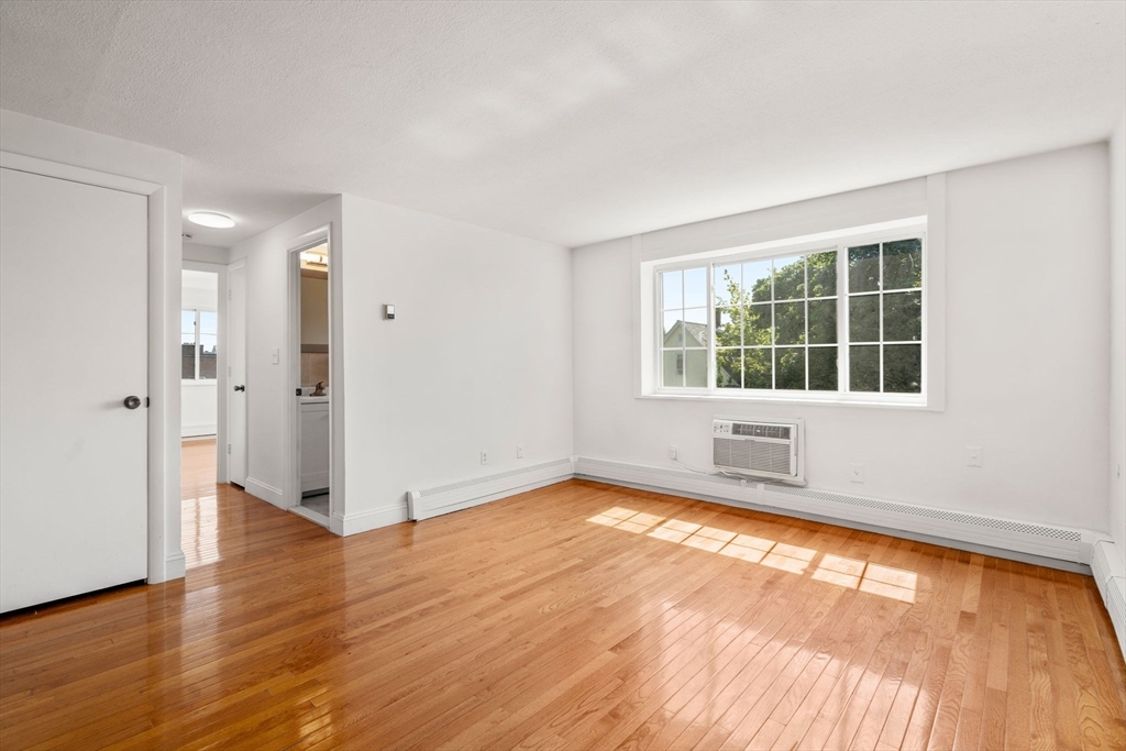 15 Staples Avenue, Unit 41 Everett, MA 02149 - Photo 3 of 9 an empty room with wooden floor and windows