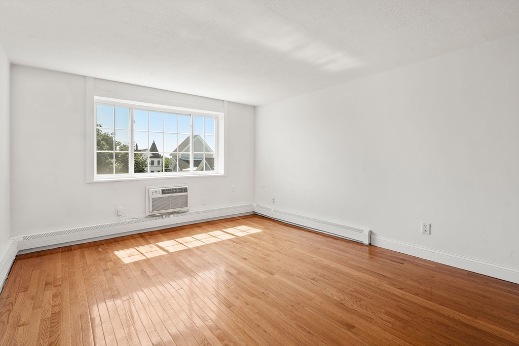 15 Staples Avenue, Unit 41 Everett, MA 02149 - Photo 4 of 9 an empty room with wooden floor and windows