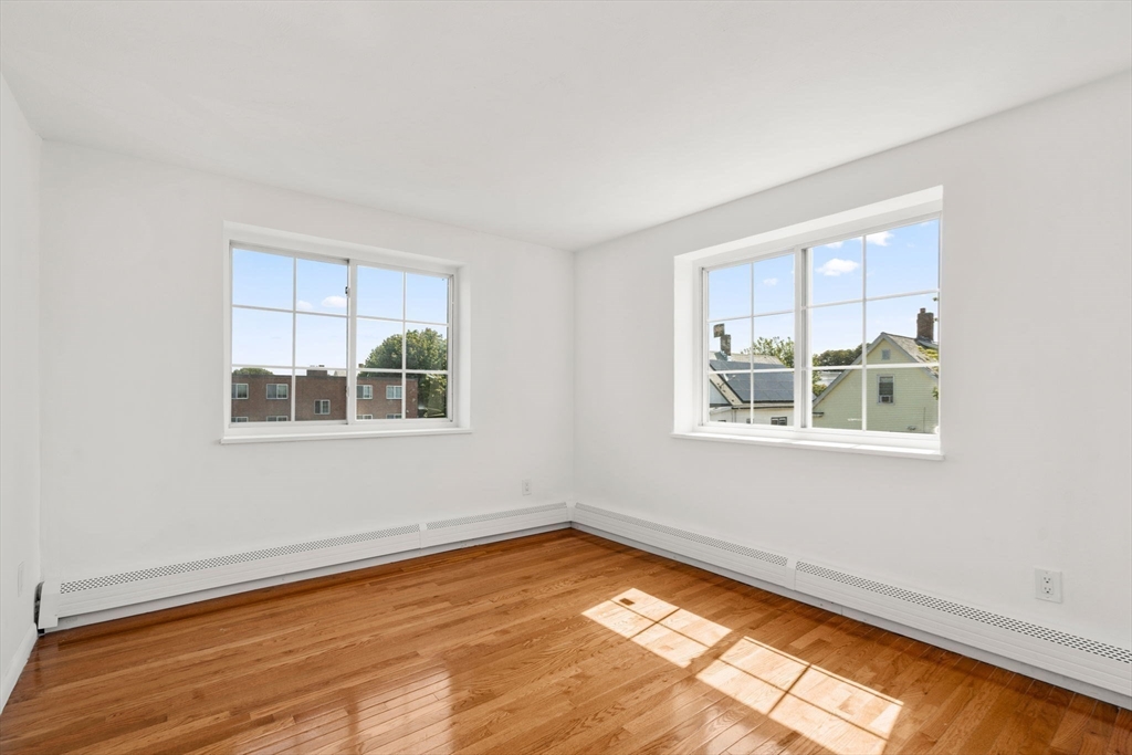 15 Staples Avenue, Unit 41 Everett, MA 02149 - Photo 7 of 9 a view of an empty room with wooden floor and a window
