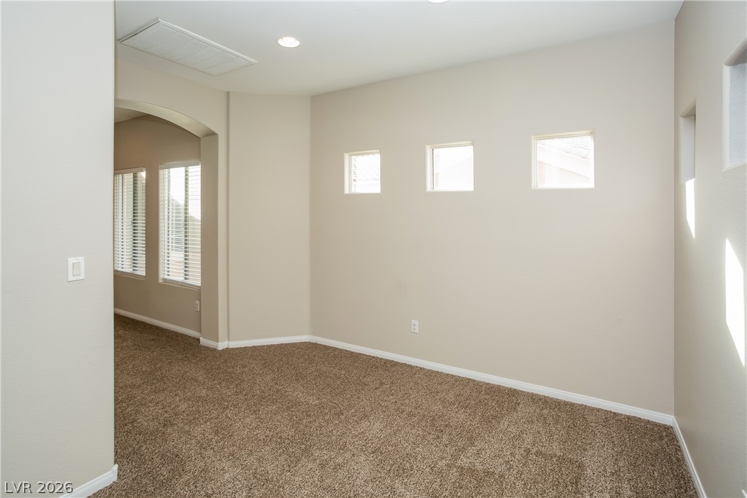7630 Riva Ridge Street Las Vegas, NV 89149 - Photo 3 of 14 Recessed lighting and clerestory windows illuminate this carpeted flex space.