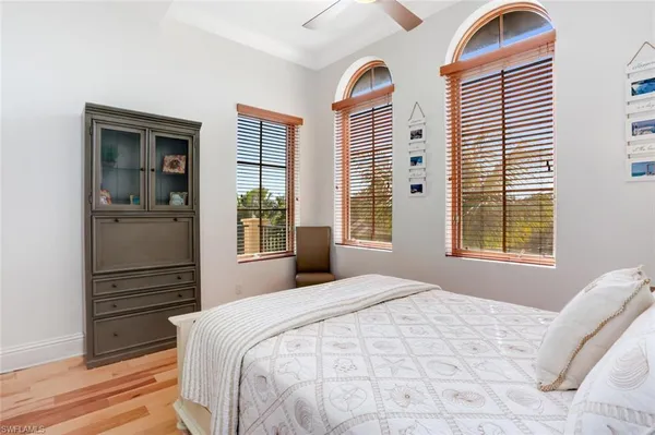 a bedroom with a bed and two windows