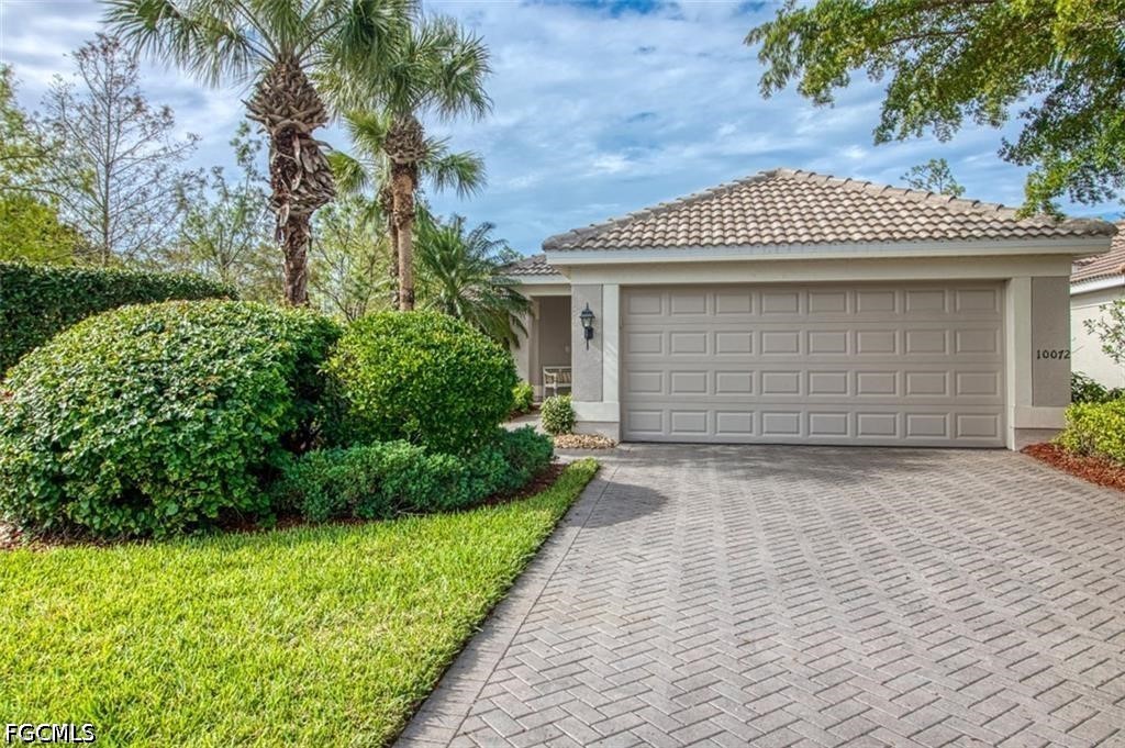 10072 Oakhurst Way Fort Myers, FL 33913 - Photo 2 of 26 a front view of a house with a garden