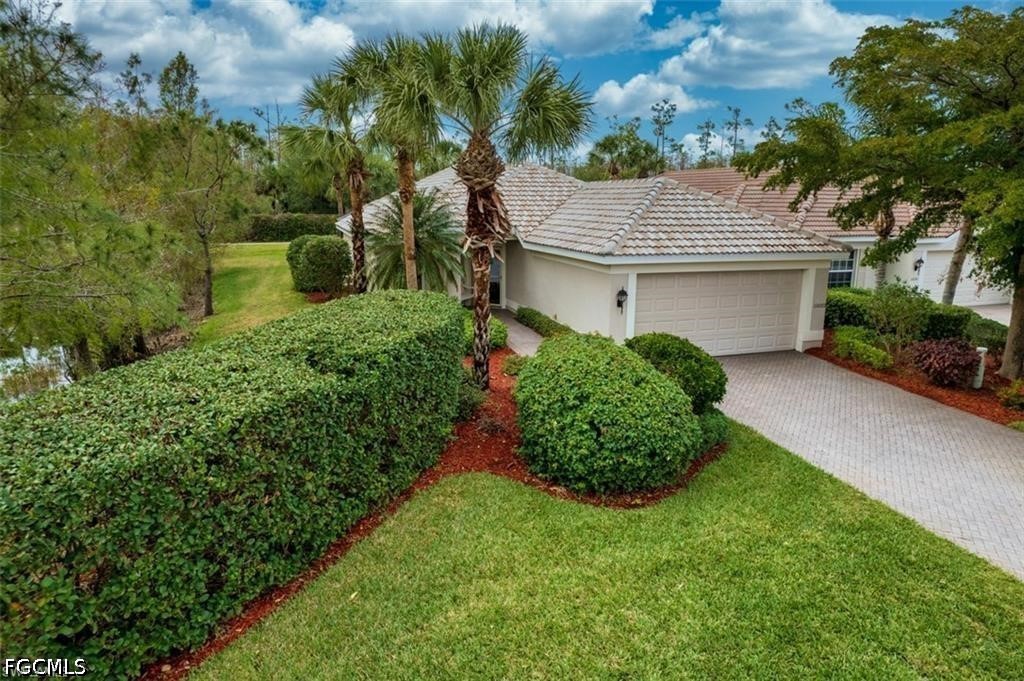 10072 Oakhurst Way Fort Myers, FL 33913 - Photo 3 of 26 a front view of a house with a garden