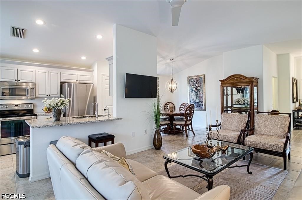 10072 Oakhurst Way Fort Myers, FL 33913 - Photo 5 of 26 a living room with furniture kitchen view and a flat screen tv