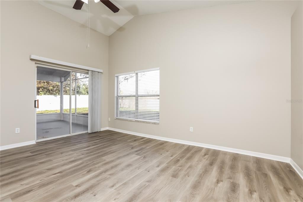 3007 East Beaumont Lane Eustis, FL 32726 - Photo 7 of 16 an empty room with wooden floor and windows