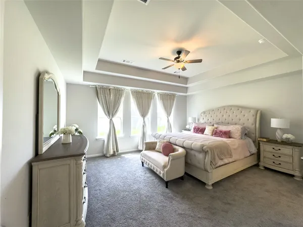 a spacious bedroom with a bed and a chandelier