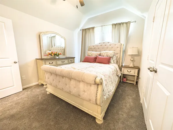 a bedroom with a bed a mirror and a window