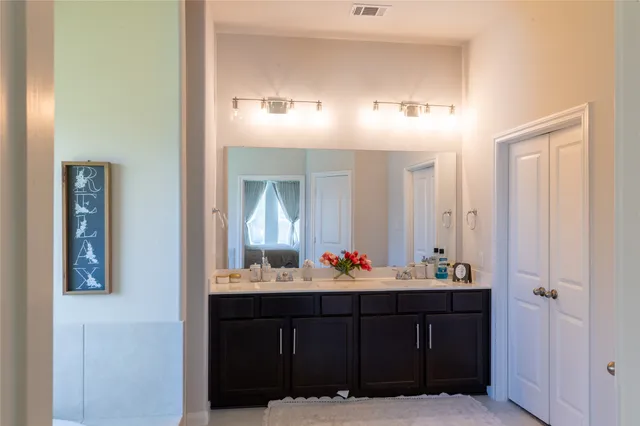 a bathroom with a sink vanity and mirror