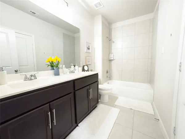a bathroom with a tub double sink and mirror