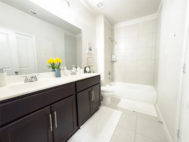 a bathroom with a tub double sink and mirror