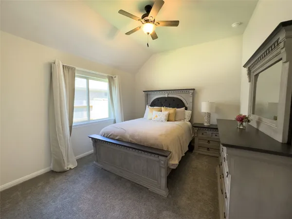 a bedroom with a bed dresser and a window