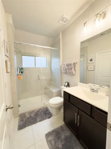 a bathroom with a sink a toilet a mirror and shower