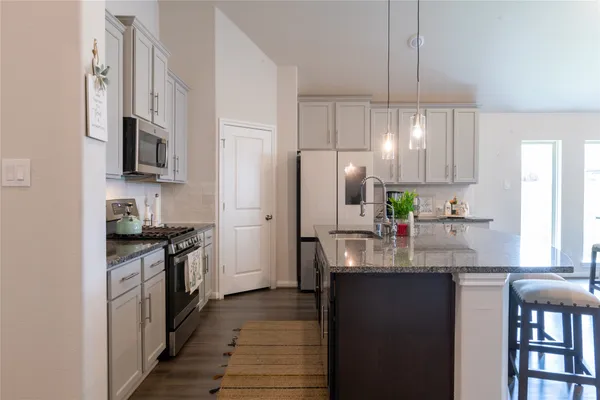 a kitchen with stainless steel appliances granite countertop a refrigerator and a stove top oven