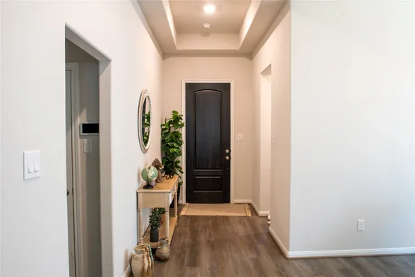 a view of a hallway with wooden floor and staircase