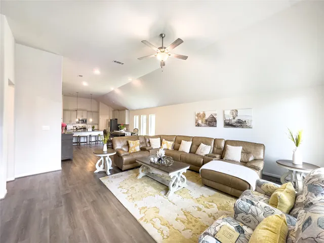 a living room with furniture and a wooden floor
