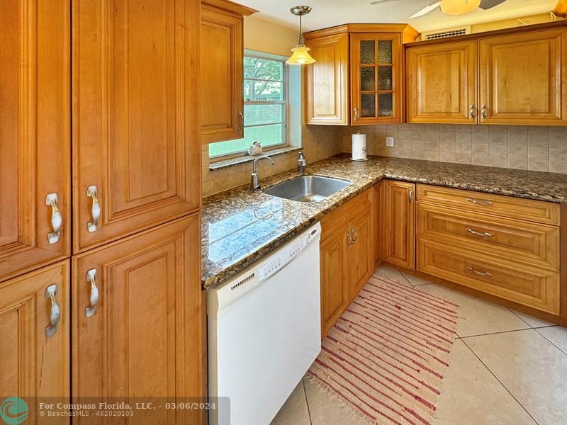 a kitchen with stainless steel appliances granite countertop a sink and a cabinets
