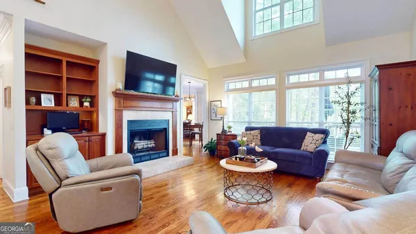 a living room with furniture fireplace and a large window