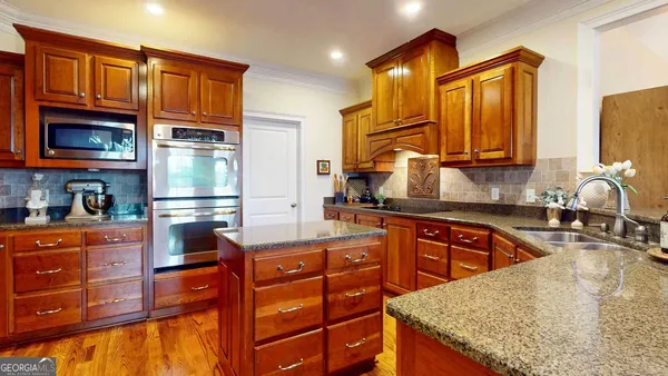 a kitchen with stainless steel appliances granite countertop a sink stove and cabinets