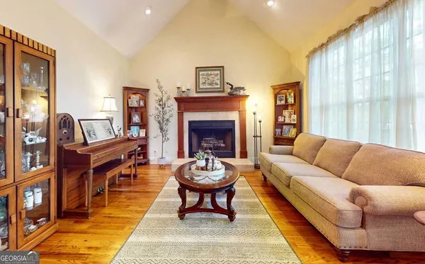a living room with furniture a fireplace and a large window
