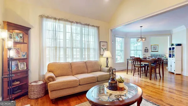 a living room with furniture a dining table and a large window