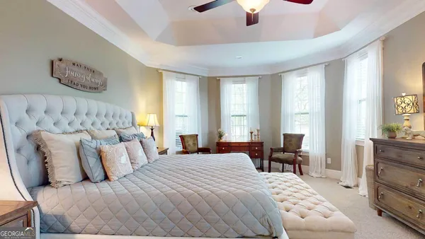 a bedroom with a bed couches and a chandelier