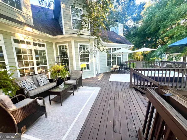 a view of a patio with couches table and chairs and wooden floor