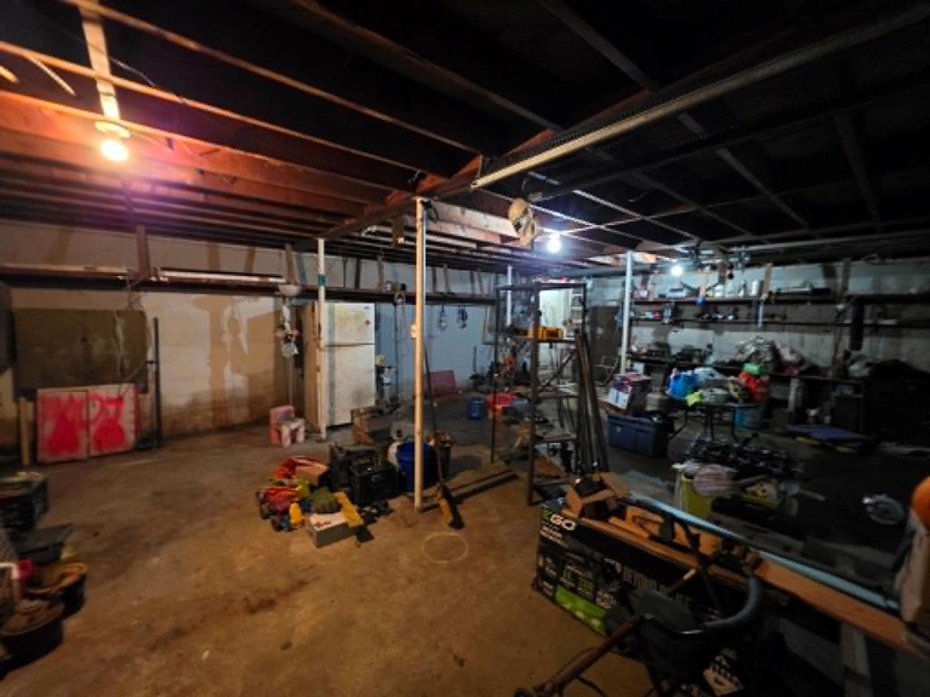 4514 West Loop 281 Longview, TX 75604 - Photo 33 of 36 Unfinished basement with exposed ceiling joists, concrete flooring, and ample storage shelving