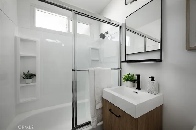 a bathroom with a sink a mirror and a shower