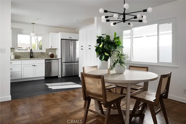 a kitchen with stainless steel appliances granite countertop a dining table chairs and granite counter tops
