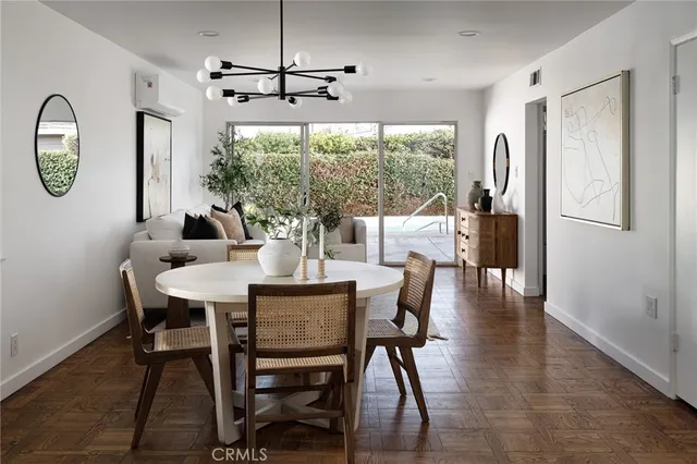a dining room with furniture a chandelier and wooden floor
