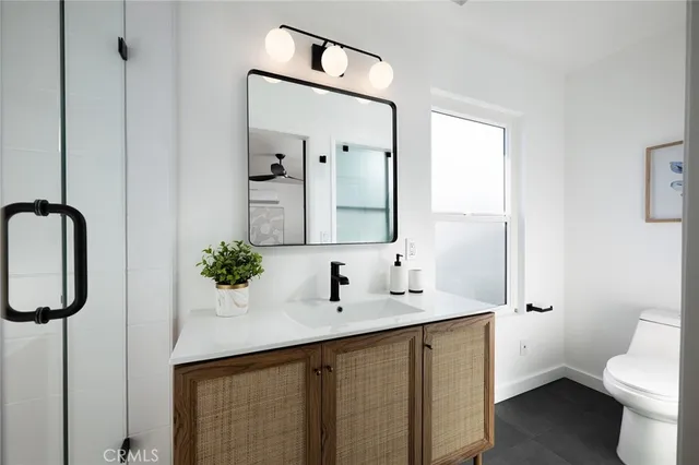 a bathroom with a double vanity sink mirror and toilet
