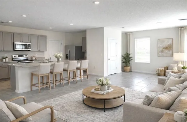 a living room with furniture kitchen and a table