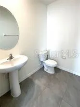 a bathroom with a sink a toilet and mirror